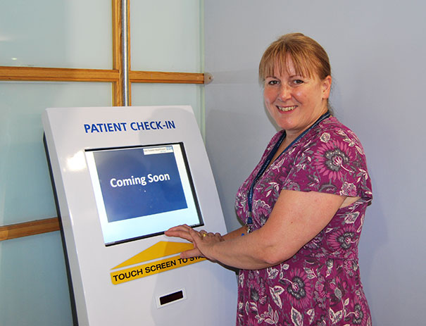 Liz Fellows, Assistant Director Operations by one of the self service check-in kiosks