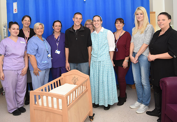 Colin and Sadie from Darvell Community present Midwifery staff with a cuddle cot