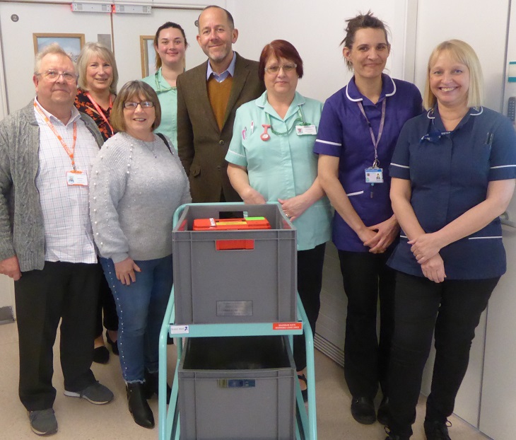 Simon Nelson at the handover of the trolley with volunteers and the Judy Beard Unit Team