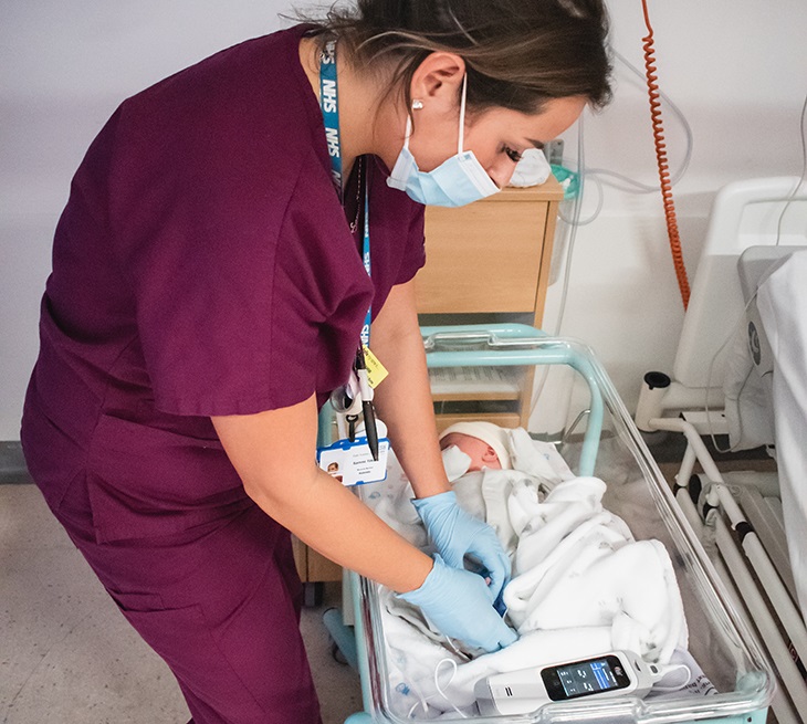 Nursery nurse Samantha Tilbury uses the monitor on newborn baby Theo