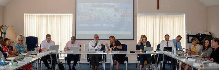 Members of the trust board sitting around the table at our annual general meeting